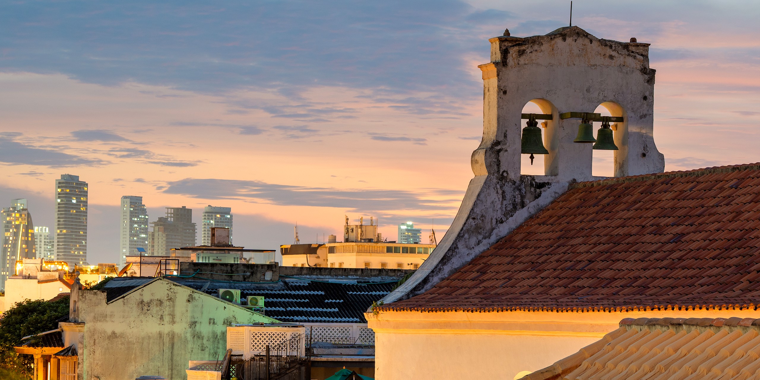 Cartagena's colonial bell tower against the modern skyline at golden hour